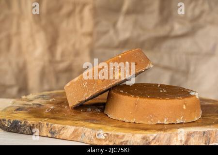 kolumbianische Panela oder Zuckerrohr Süßigkeiten, bereit, in verschiedenen typischen Gerichten verzehrt werden. Piloncillo bereit für den Verkauf und die Vermarktung, auf einem Woo platziert Stockfoto