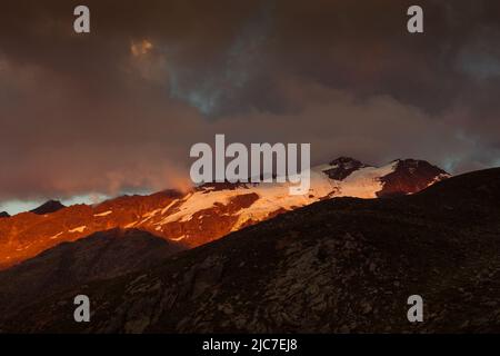 Dramatische Sonnenuntergangsfarben auf Gipfeln rund um den Fontana-Gletscher, Südtirol, Italien Stockfoto