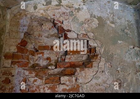 Zerstörte Mauer in einem alten roten Backsteingebäude Stockfoto