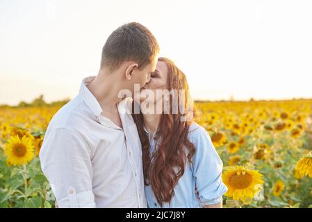 Küssen junges Paar Porträt auf Sonnenblumen Feld. Eine Liebesgeschichte Stockfoto