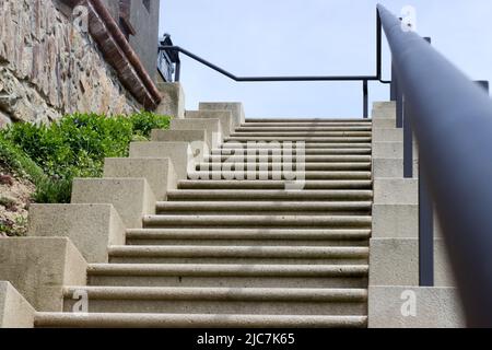 Betontreppe mit Eisengeländer, Steinmauer Stockfoto