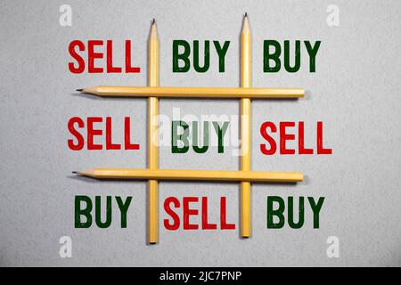 Würfel mit den Worten verkaufen kaufen, Bleistift und finanzielle Diagramm schnetzelt. Selektiven Fokus. Stockfoto