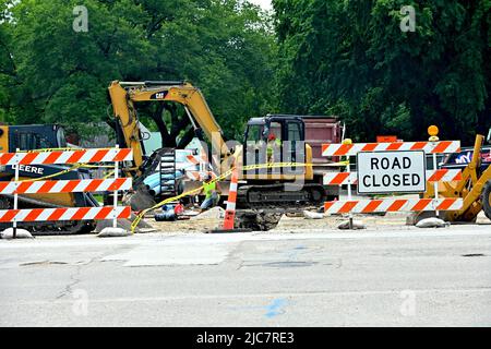 EMPORIA, KANSAS - 10. JUNI 2022 im Rahmen eines monatelangen Projekts zur Verbesserung der Infrastruktur für die wirtschaftliche Entwicklung, das sich nun in der Endphase befindet, haben die Bauunternehmer einen Graben aus der neuen Hauptleitung ausgegraben, die entlang der W 6. Avenue South auf der Wilson Street verläuft, und bereiten sich auf den Bau neuer kleinerer Wasserleitungen vor (Blaue Rohre) in den Graben, um die Verbindung zu den Residenzen weiter die Straße hinunter zu überqueren Stockfoto