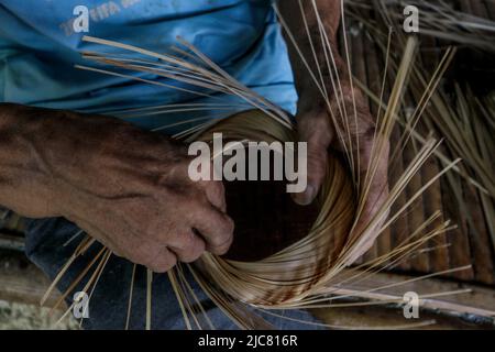 Heimwerker fertigen am 7. Juni 2022 umweltfreundliche Reisbehälter aus gewebtem Bambus in Bogor, West Java, Indonesien Stockfoto