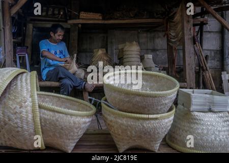 Heimwerker fertigen am 7. Juni 2022 umweltfreundliche Reisbehälter aus gewebtem Bambus in Bogor, West Java, Indonesien Stockfoto