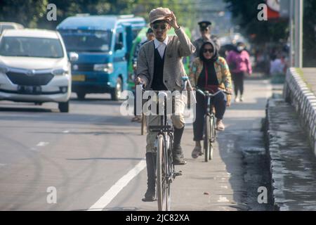 Mitglieder der Onthel Community fahren gemeinsam mit der Indonesischen Old Bike Community um die Stadt, um den Weltfahrradtag zu feiern Stockfoto