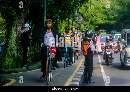 Mitglieder der Onthel Community fahren gemeinsam mit der Indonesischen Old Bike Community um die Stadt, um den Weltfahrradtag zu feiern Stockfoto