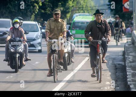 Mitglieder der Onthel Community fahren gemeinsam mit der Indonesischen Old Bike Community um die Stadt, um den Weltfahrradtag zu feiern Stockfoto