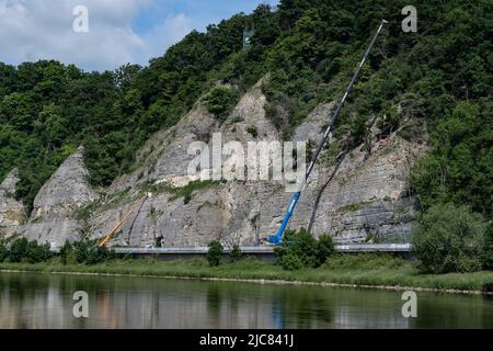 PRODUKTION - 08. Juni 2022, Niedersachsen, Dölme: Blick auf die Felswand mit Kränen auf der Bundesstraße 83 zwischen den Städten Pegestorf und Steinmühle an der Weser. Seit einiger Zeit wurde die Bundesstraße saniert und die Felswand gesichert. (Zur dpa 'Bundesstraße in Holzminden wird Ende August eröffnet') Foto: Swen Pförtner/dpa Stockfoto