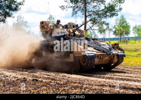 Deutschland. 24.. Mai 2022. Ein Kampffahrzeug M2A3 Bradley, das 1. Bataillon, 8. Infanterie-Regiment, 3. Panzerbrigade-Kampfteam, 4. Infanterie-Division zugewiesen wurde, kommt während einer Live-Feuerübung im Rahmen von DEFENDER-Europe 22 auf dem Trainingsgelände Oberlausitz, Deutschland, 24. Mai 2022, vor. DEFENDER-Europe 22 ist eine Reihe von multinationalen Trainingsübungen der US Army Europe und Africa im Rahmen des großen globalen Trainingskonstrukts des US European Command, das in Osteuropa stattfindet. DEFENDER-Europe 22 demonstriert die Fähigkeit der US-Armee in Europa und Afrika, umfangreiche Bodenkampfoperatio durchzuführen Stockfoto