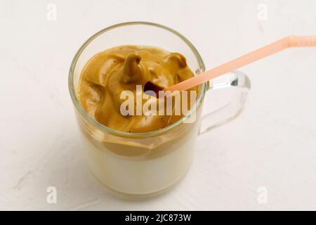 Dalgona Kaffee ist ein cremiges Schlaggetränk mit Kaffeeschaum und Milch. Modisches Getränk. Selektiver Fokus Stockfoto