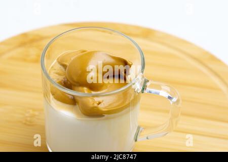 Dalgona Kaffee ist ein cremiges Schlaggetränk mit Kaffeeschaum und Milch. Modisches Getränk. Selektiver Fokus Stockfoto