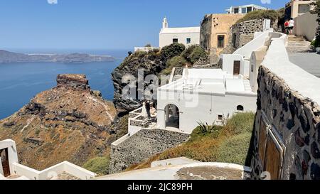 Blick über Häuser auf steilen Klippen zum Skaros Rock außerhalb von Imerovigli auf der Insel Santorini Stockfoto