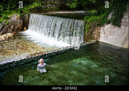 Blonde Frau im Badeanzug Baden in den heißen Quellen von Loutra Pozar Stockfoto