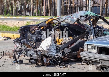 Geschossene, beschädigte Autos während des Krieges in der Ukraine. Das Fahrzeug von Zivilisten, die von den Händen des russischen Militärs betroffen sind. Schrapnel und Einschusslöcher in der Stockfoto