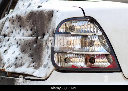 Geschossene, beschädigte Autos während des Krieges in der Ukraine. Das Fahrzeug von Zivilisten, die von den Händen des russischen Militärs betroffen sind. Schrapnel und Einschusslöcher in der Stockfoto