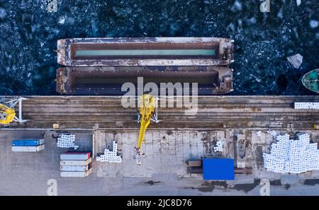 Luftaufnahme von oben auf den Flusshafen mit Portalkranen. Krane im Frachthafen von Togliatti im Winter Stockfoto