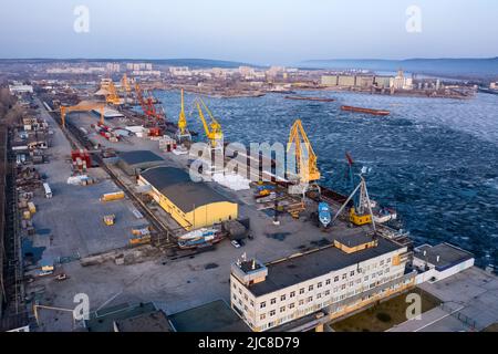 Blick auf den Flusshafen mit Portalkranen. Krane im Frachthafen von Togliatti im Winter. Stockfoto