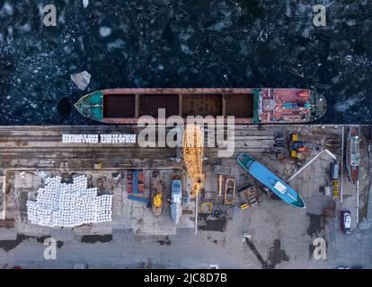 Luftaufnahme von oben auf den Flusshafen mit Portalkranen. Krane im Frachthafen von Togliatti im Winter Stockfoto