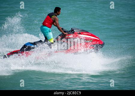 Ein junger indischer Mann, der einen Jet-Ski im Arabischen Golf, Kuwait-Stadt, fährt Stockfoto