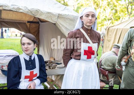 MOSKAU, RUSSLAND - 11. Juni 2022. Das jährliche Festival Times und Epochen. Frauen Schauspielerinnen in Form von Ärzten und Krankenschwestern auf dem Hintergrund eines Militärs Stockfoto