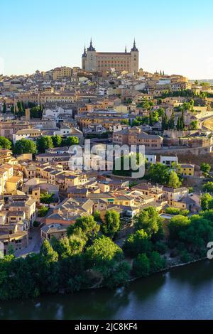 Häuser der Stadt Toledo mit dem beeindruckenden Alcazar auf einem Hügel und stromabwärts. Stockfoto