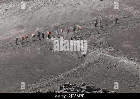 Trekking von Wanderern und Touristen, die zum Vulkankrater Ätna -Sizilien zu Fuß Stockfoto