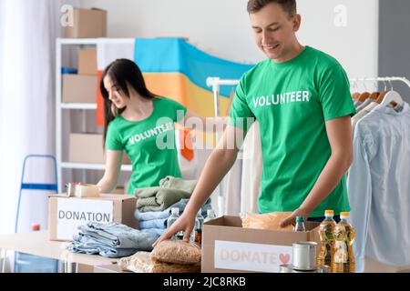 Polnischer Freiwilliger, der Lebensmittel in eine Spendenbox für die Ukraine in der Mitte einlegt Stockfoto