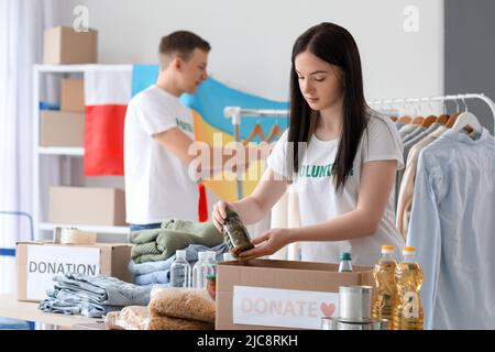 Polnischer Freiwilliger, der Konserven in eine Spendenbox für die Ukraine in der Mitte stecken lässt Stockfoto