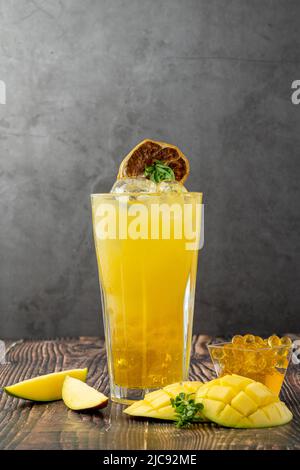 Mangolemonade mit Bubble Tea auf dunklem Holzhintergrund Stockfoto