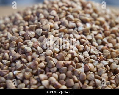 Organischer Buchweizen groats Makro Hintergrund. Geröstete, trockene Buchweizenkörner, Textur aus der Nähe. Vollkorn-Buchweizensamen für glutenfreie Ernährung, vegetarisch Stockfoto