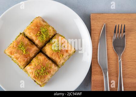 Traditionelle Pistazien Baklava in weißer Platte.Eine Platte Baklava auf Holzgrund Stockfoto