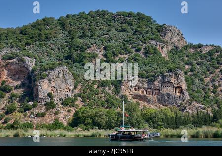 Touristenschiff vor lykischen Felsgräbern in einer Felswand von Dalyan, Türkei Stockfoto