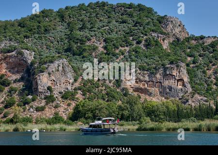 Touristenschiff vor lykischen Felsgräbern in einer Felswand von Dalyan, Türkei Stockfoto