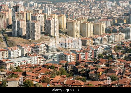 Das moderne Gebäude wird neben verkommenen traditionellen Wohnhäusern in Ankara, der türkischen Hauptstadt, gebaut. Stockfoto