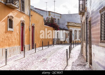 Malerische Seitenstraße, die sich in der späten Nachmittagssonne sonnt - Tavira, Portugal Stockfoto
