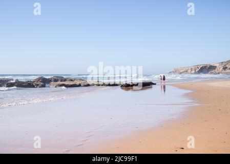Besucher genießen die Nachmittagssonne am Strand Praia de Monte Clerico an der Algarve, Portugal Stockfoto