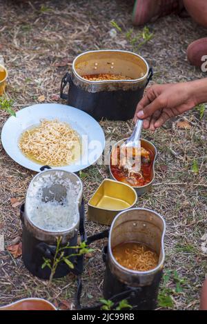 Camping und Kochen von Lebensmitteln im Urlaub von Kindern in ländlichen Gebieten. Stockfoto