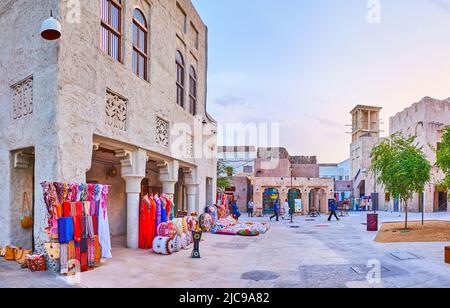 Die bunten Kleidungsstücke, Accessoires, Kunsthandwerk und Souvenirs an den Außenständen des Touristenmarktes in Al Seef, Dubai, VAE Stockfoto