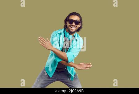 Studio-Porträt eines glücklichen indischen Mannes in legerer Kleidung und Sonnenbrillen tanzen und Spaß haben Stockfoto