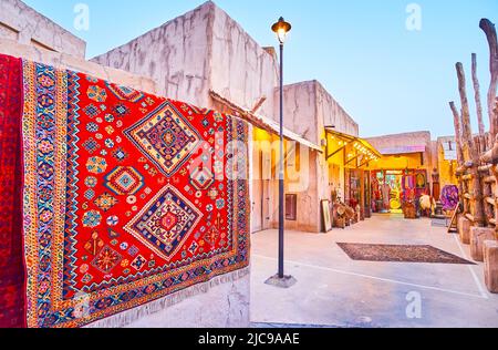 Der Straßenmarkt im Viertel Al Seef mit bunten Teppichen, Souvenirs, Kleidungsstücken und Accessoires, Dubai, VAE Stockfoto