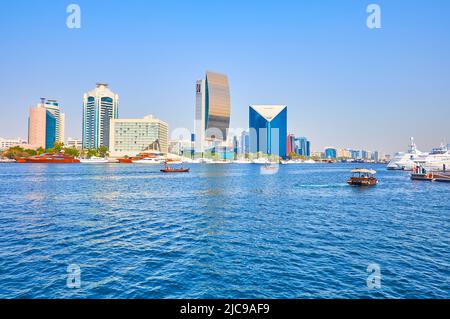 DUBAI, VAE - 1. MÄRZ 2020: Das wellige blaue Wasser von Dubai Creekvor moderner Deira-Architektur mit der Dubai National Bank und der Kammer der Kommerin Stockfoto