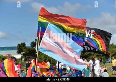 Menschen treffen sich am Startpunkt der Portsmouth Pride 2022 Parade. Helle Regenbogenfarben in der einen oder anderen Form sorgen für einen bunten Tag. Stockfoto