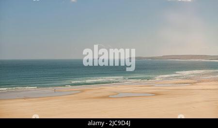 St Ives, Großbritannien. 11.. Juni 2022. Ein Zug fährt auf der malerischen St Ives Bay Railway Line durch den Lelant Beach im Hintergrund, auf dem Weg nach St Ives Credit: kathleen White/Alamy Live News Stockfoto