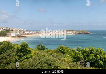 St Ives, Großbritannien. 11.. Juni 2022. Ein Zug fährt auf der malerischen St Ives Bay Railway Line durch den Lelant Beach im Hintergrund, auf dem Weg nach St Ives Credit: kathleen White/Alamy Live News Stockfoto