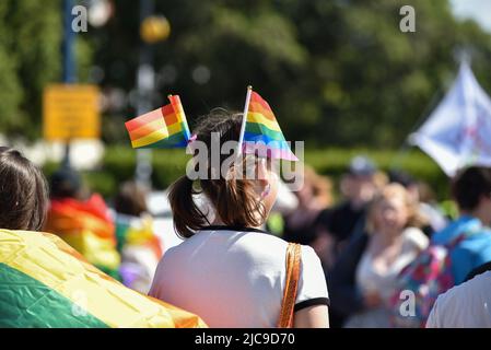 Menschen treffen sich am Startpunkt der Portsmouth Pride 2022 Parade. Helle Regenbogenfarben in der einen oder anderen Form sorgen für einen bunten Tag. Stockfoto