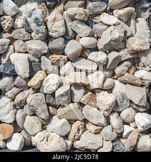 Mischung aus Steinen. Viele Steine im Bausieb. Verwendung von Steinen für Entwässerung, Landschaftsbau, Bau. Stockfoto