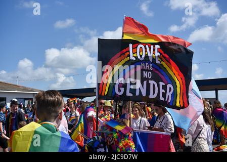 Menschen treffen sich am Startpunkt der Portsmouth Pride 2022 Parade. Helle Regenbogenfarben in der einen oder anderen Form sorgen für einen bunten Tag. Stockfoto