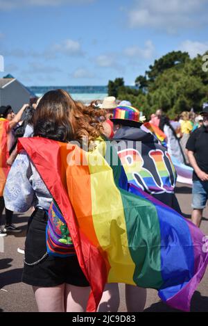 Menschen treffen sich am Startpunkt der Portsmouth Pride 2022 Parade. Helle Regenbogenfarben in der einen oder anderen Form sorgen für einen bunten Tag. Stockfoto