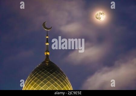 Eine muslimische Kuppel mit einem Halbmond auf der Moschee. Minarett auf dem Hintergrund des Mondes. Die arabische Nacht. Islamische Symbole der Religion. Vertrauen. Fee Stockfoto